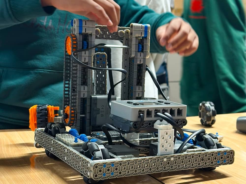Hands fitting parts onto a VEX IQ robot